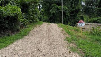 A gravel path leading through a wooded area with a stop sign indicating it's not an exit.