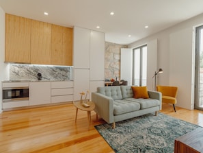 A modern living space with a kitchen, a sofa, and a dining area. - Apartment  by Interhome (Porto)