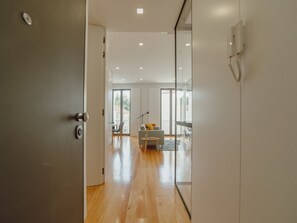 A modern interior with a wooden floor, a sofa, and a dining area with chairs. - Apartment  by Interhome (Porto)