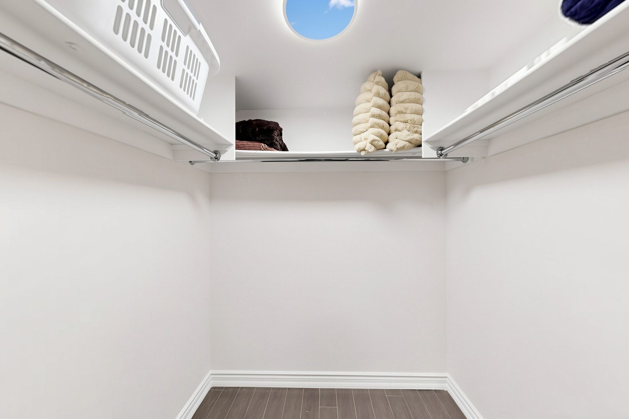 Un intérieur blanc avec une lucarne, un plafond blanc et un plancher en bois.