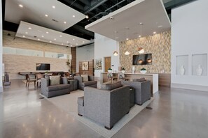 Ein modernes Interieur mit Sofas, einem Flachbildfernseher und einer Wand mit Muster.