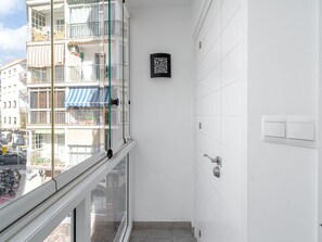 A narrow balcony with a glass door, a white wall with a black decorative panel, and a door with a modern handle. - Apartamento Urban Suite by Casasol by Interhome (Nerja)