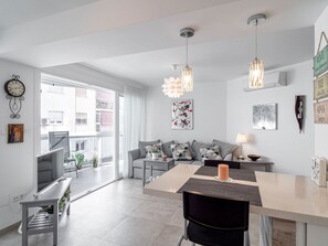 A modern living room with a sofa, coffee table, and pendant lights. - Apartamento Urban Suite by Casasol by Interhome (Nerja)