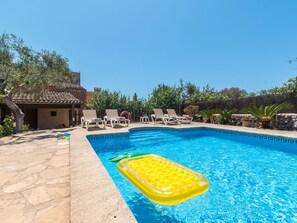 Una piscina con sillas de descanso y un flotador inflable.