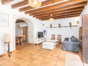A living room with a TV, seating, and a dining area. - Finca Can Nin by Interhome (Santanyí)