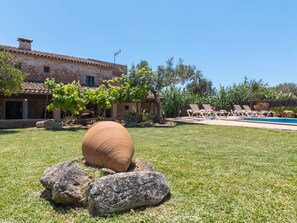 A stone building with a tiled roof, a swimming pool, and lounge chairs. - Finca Can Nin by Interhome (Santanyí)