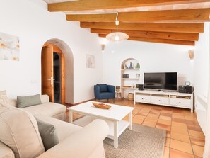 A modern living room with a sofa, coffee table, TV, and a bookshelf. - Finca Can Nin by Interhome (Santanyí)