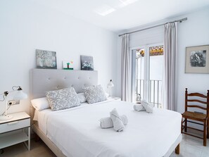 A hotel room with a bed, bedside tables, a chair, and artwork on the walls. - Casa Animas Centro by Casasol by Interhome (Nerja)