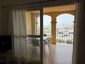 A room with a sliding glass door leading to an outdoor balcony with a view of a parking area and buildings. - Milenio 1H Apartment by Casasol by Interhome (Nerja)