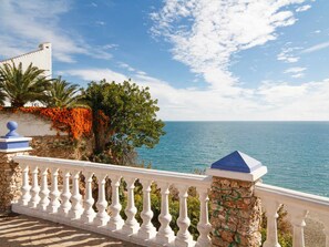 Ein Küstenbalkon mit weißer Brüstung mit Blick auf das Meer.