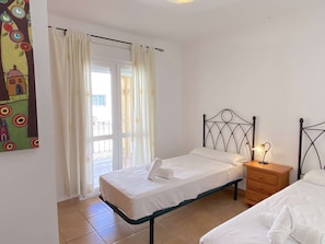 A bedroom with a single bed, a nightstand, and a window with curtains. - Milenio 1H Apartment by Casasol by Interhome (Nerja)