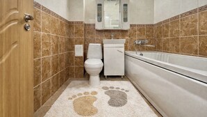 Un baño con inodoro, lavamanos y bañera.