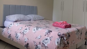 Un dormitorio con cama, armario y ventilador de techo.
