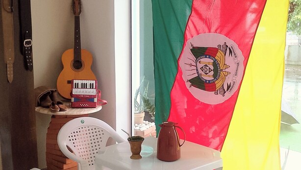 Una habitación con una guitarra, un teclado y una mesa con una silla.