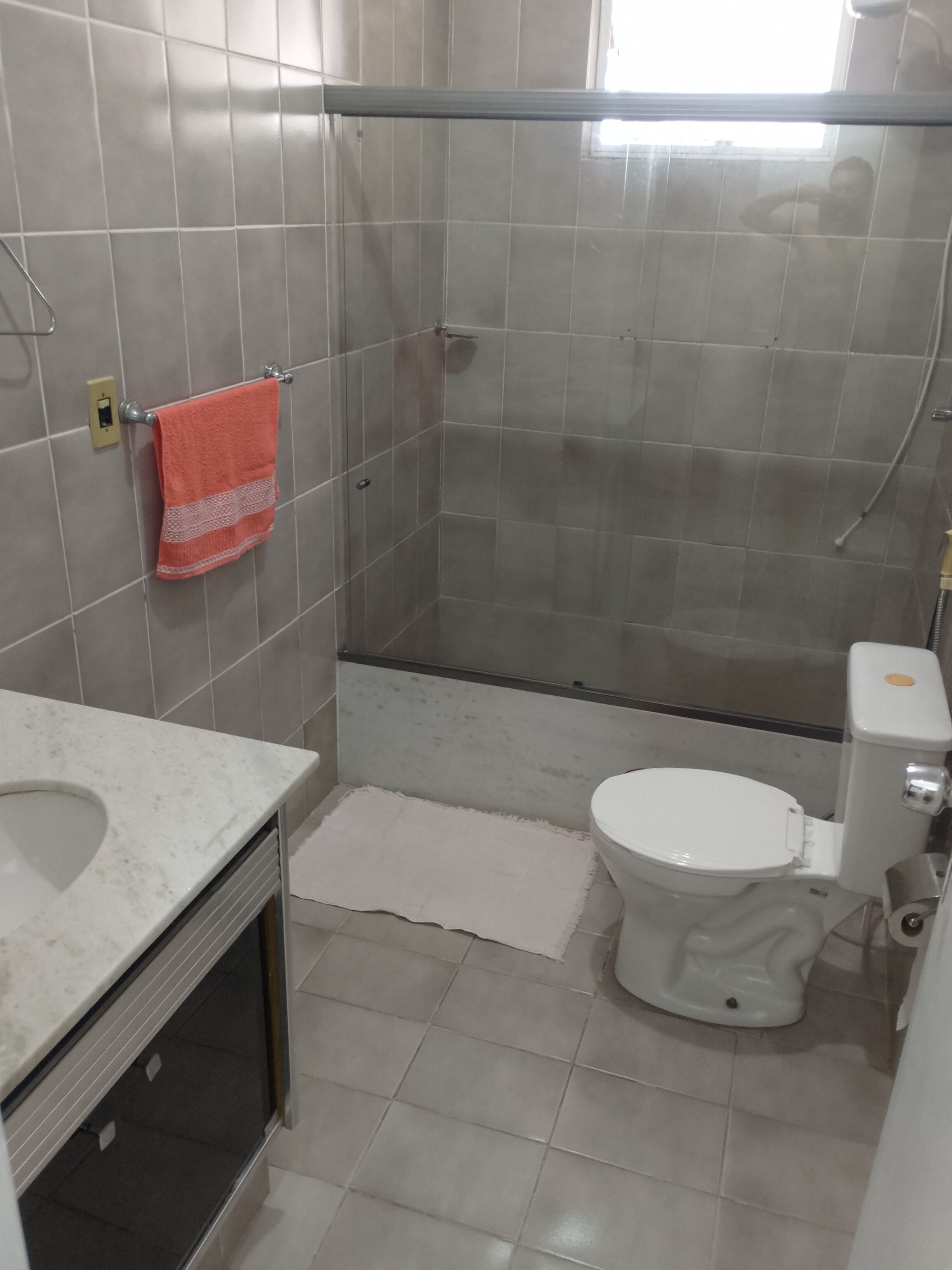 Ein Badezimmer mit Dusche, Toilette und Waschbecken.