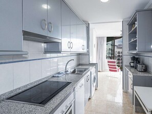 Een moderne keuken met roestvrijstalen apparatuur, een granieten aanrechtblad en uitzicht op de stad.