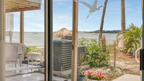 A room with a view of the sea, a pergola, outdoor furniture, and a large air conditioning unit. - Relax Beachside! Tropical Resort Amenities 1B1B (St. Petersburg)