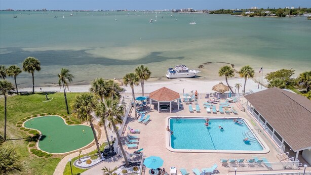 A resort with a swimming pool, a tennis court, and a view of the ocean. - Relax Beachside! Tropical Resort Amenities 1B1B (St. Petersburg)