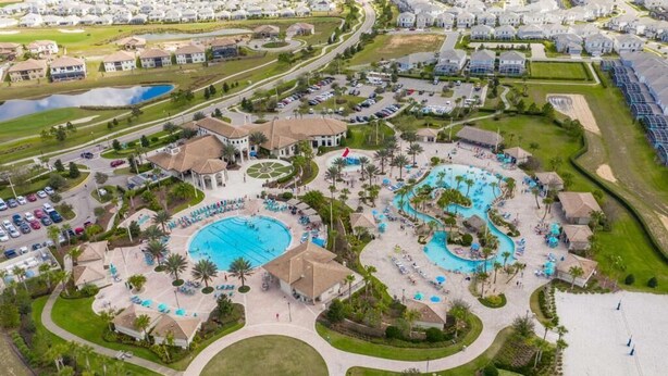 Vista aerea di un resort con diverse piscine, un gazebo centrale e una strada circostante.