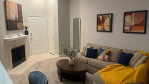 A living room with a sofa, coffee table, and a fireplace. - Quiet Enjoyment in Houston Medical Center (Houston)