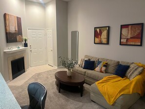 Ein Wohnzimmer mit einer Couch, einem Couchtisch und einem Kamin.