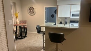 A modern kitchen with white cabinets, a built-in oven, and a countertop with a blender. - Quiet Enjoyment in Houston Medical Center (Houston)