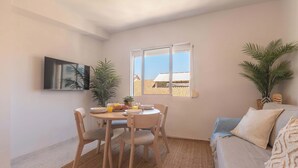 A dining area with a table, chairs, and a window with a view. - 6th floor Malaga Soho Apartment (Málaga)