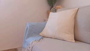 A sofa with a light-colored throw blanket and a cushion. - 6th floor Malaga Soho Apartment (Málaga)