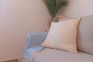 Ein Sofa mit einer hellen Decke und einem Kissen.