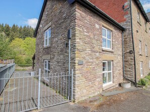 A stone building with a metal gate, a sign reading 'Little Penwynn,' and a window with a potted plant. - Little Pentwyn (Hereford)