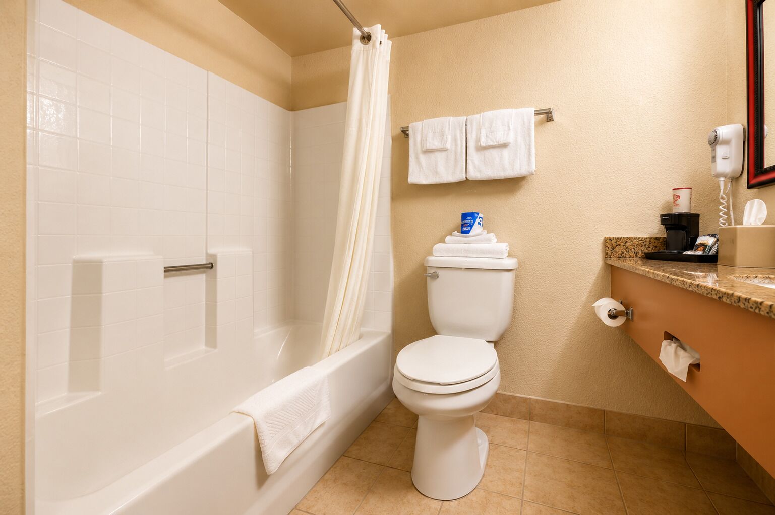 A bathroom with a bathtub, toilet, and shower curtain.