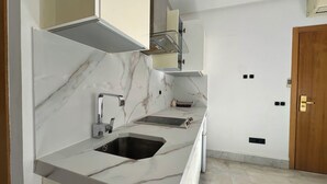 Una cocina moderna con encimera de mármol, un lavamanos y un horno empotrado.