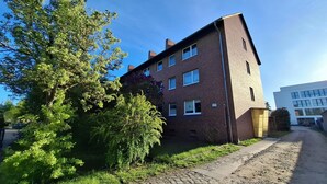 A multi-story brick building with a paved driveway and a tree in front. - Room "grey" in shared flat - central and quiet - VW, Autostadt, VfL parking lot and WLAN (Wolfsburg)