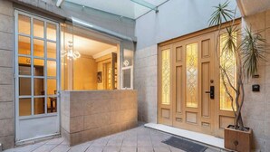 A reception area with a glass door, a wooden door with intricate patterns, and a potted plant. - Prime Polanco Stay With Patio, Near Shops & Cafes (Ciudad de México)