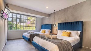 A bedroom with two beds, a large window, and a modern design.