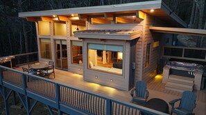 En moderne hytte med terrasse, grill og boblebad.