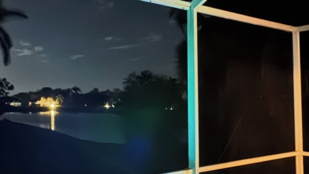 Un bain à remous à l’intérieur d’une structure en verre, offrant une vue sur le ciel nocturne et les lumières lointaines.