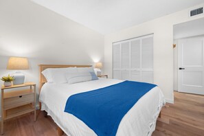 A neatly arranged bedroom with a bed, bedside tables, a lamp, and a wardrobe. - 2BR Family Retreat - River Views, Pool & Tennis, Sleeps 6 (St. Augustine)
