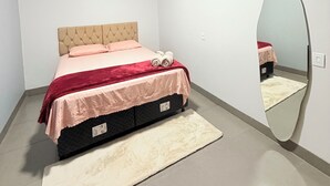 A bedroom with a bed, a mirror, and an air conditioning unit. - Edifício VIvaVida (Sinop)