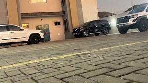 A multi-story building with a flat facade, parking area, and a Toyota SUV. - Edifício VIvaVida (Sinop)