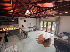 A spacious kitchen with a large island, a dining area with a table and chairs, and a large window with a view of the outdoors. - Welcoming 1-bedroom house with AC / pool / table tennis in vibrant Los Angeles (Los Angeles)