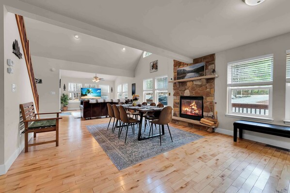 A spacious living area with a fireplace, dining table, and comfortable seating.