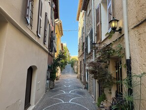A narrow cobblestone street flanked by buildings with shutters and a street lamp. - Viel Antibes - studio rénové & plein de charme (Antibes)