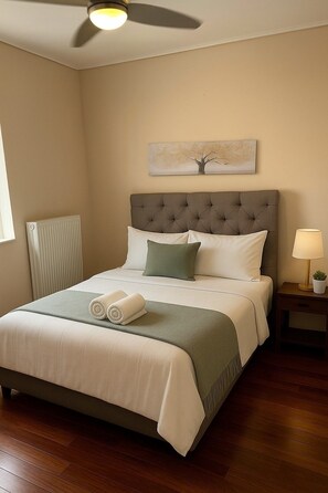 A neatly made bed with a grey headboard, a bedside lamp, and a radiator on the wall. - Navarinou Kalamata Pearl Cozy Seaside apartment (Kalamata)