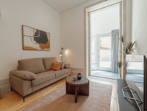 Un saló modern amb un sofà, una taula de centre i un quadre a la paret.
