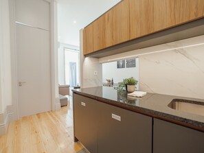 Eine moderne Küche mit Holzausstattung, einer Marmorarbeitsplatte und einem eingebauten Geschirrspüler.