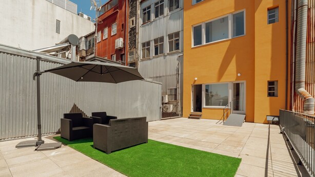 Un'area patio esterna con un angolo salotto e una zona riparata.
