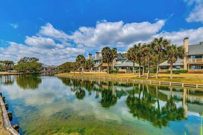 A waterfront property with a clear lake, reflecting the surrounding buildings and trees. - ALL NEW Family Jewel Myrtle Beach (MYRTLE BEACH)