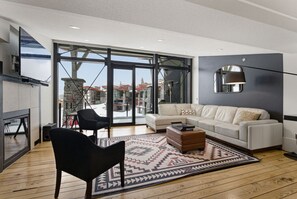 A modern living room with a sofa, chairs, a coffee table, and a fireplace.