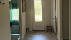 A hallway with a door, a rug, and a basket.